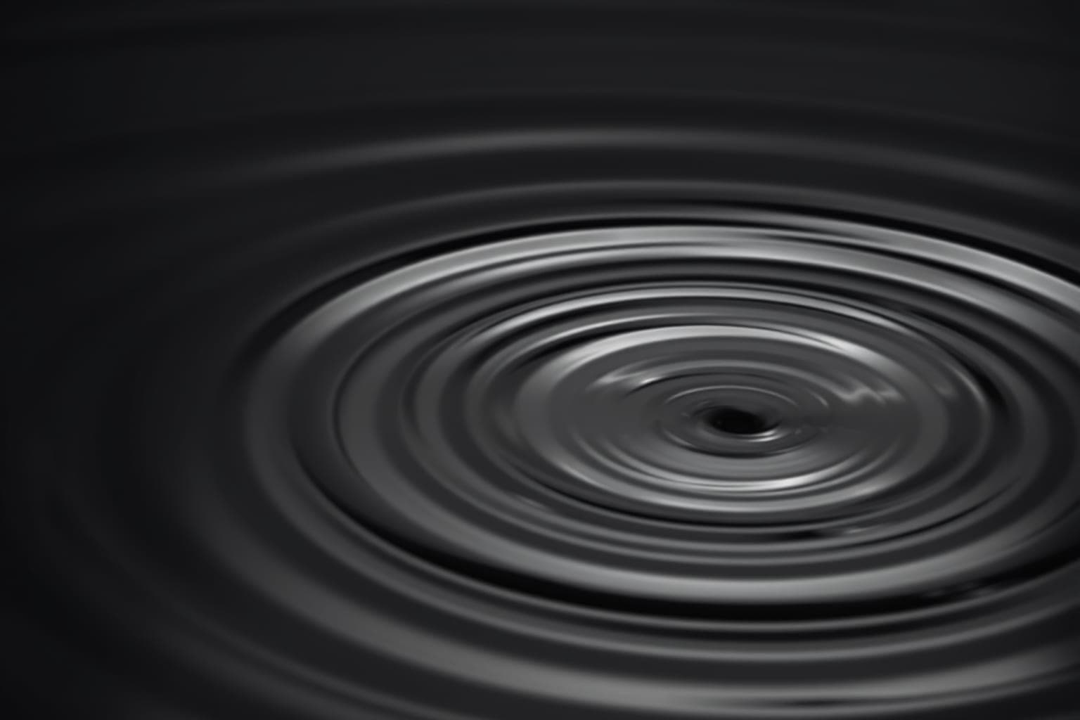 Dark water with soft concentric ripples catching a thin line of light.
